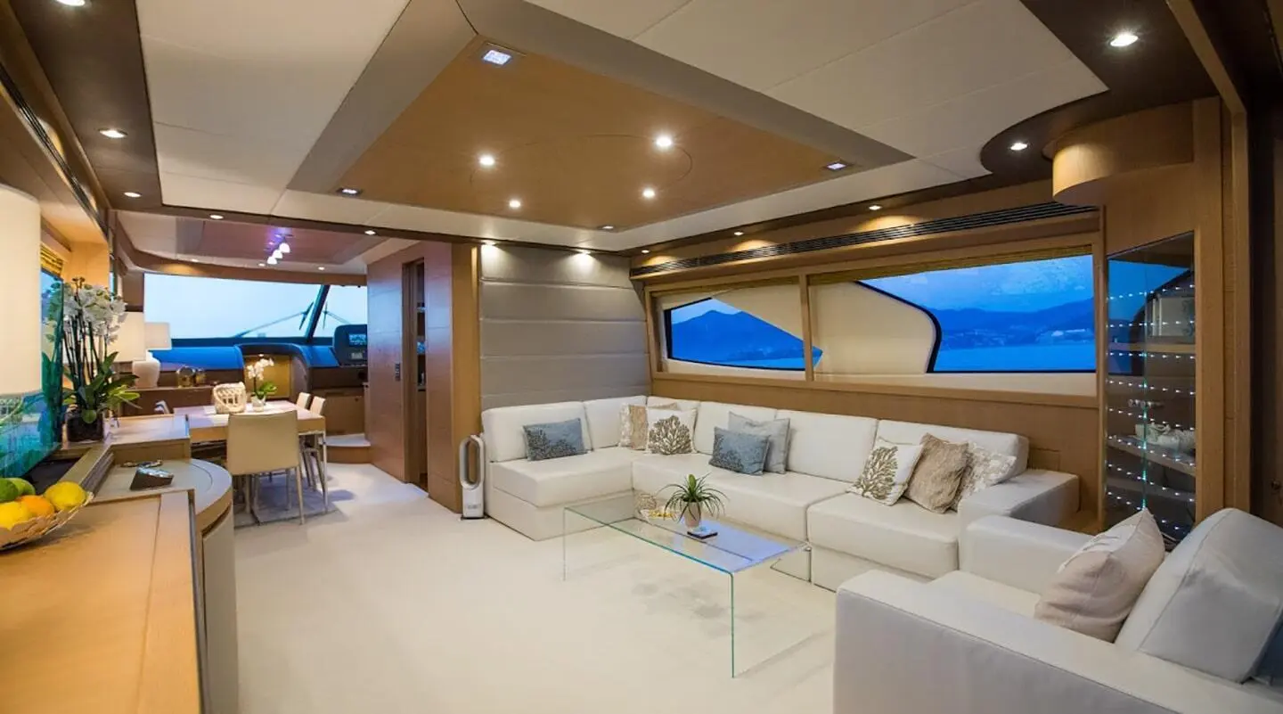 Interior salon of Salt yacht with white sofa seating, wood accents, and blue lighting