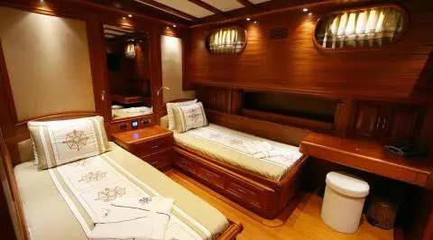 Interior of Kaya Guneri 5 gulet with wooden cabin, twin beds, porthole light