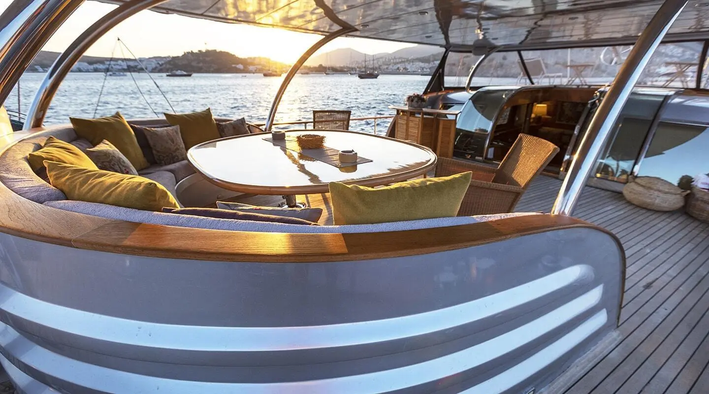 Silver Moon yacht with white deck, blue hull, on calm water at sunset