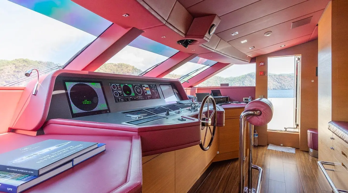 Yacht Takara One helm area at sunset with red cabin interior and steering wheel