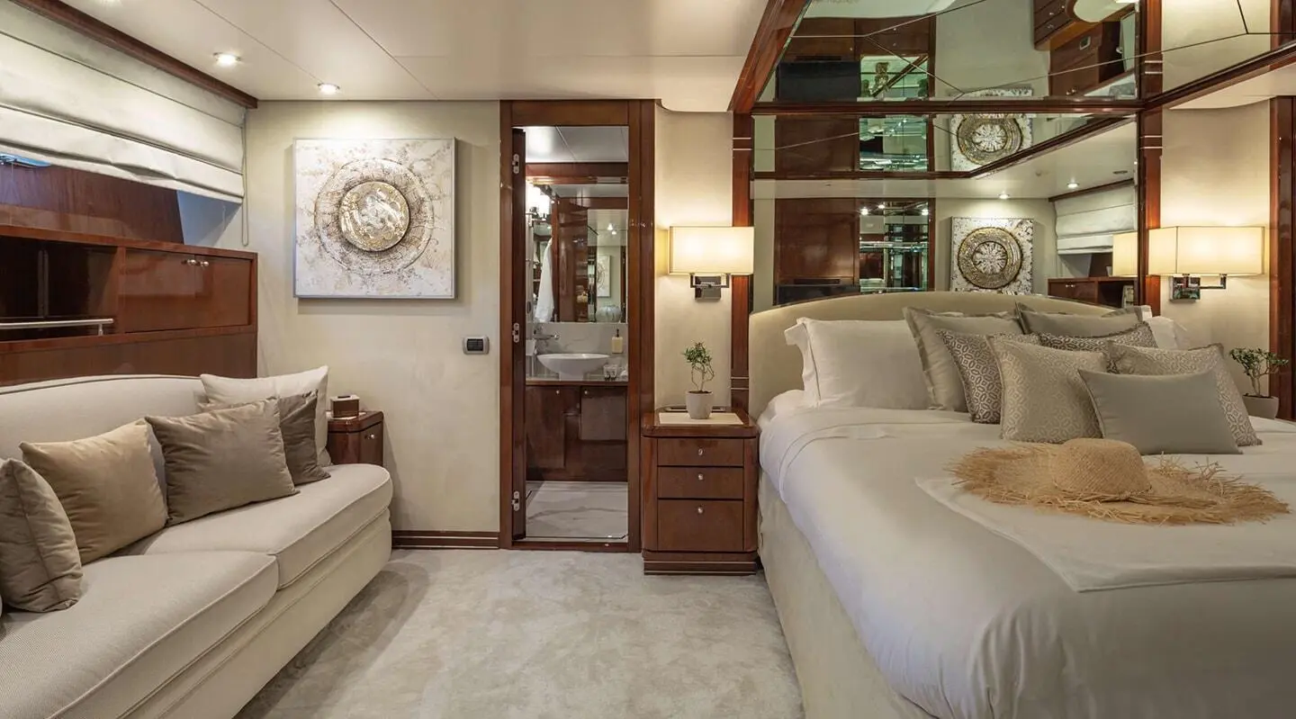 Grace yacht bedroom interior with bed, wooden furniture, and beige decor