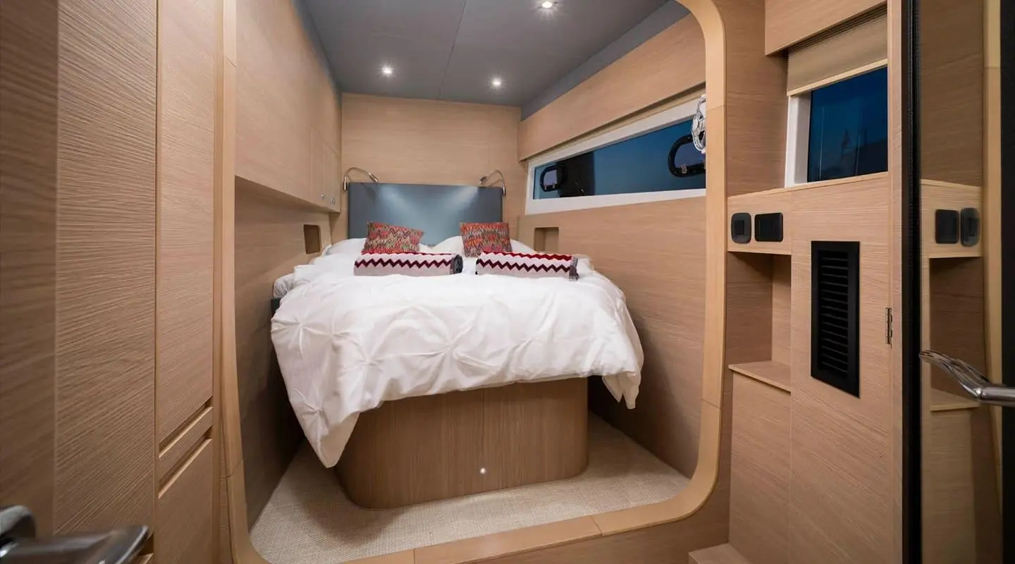 Cozy yacht cabin with bed, wooden panels, porthole window, soft lighting