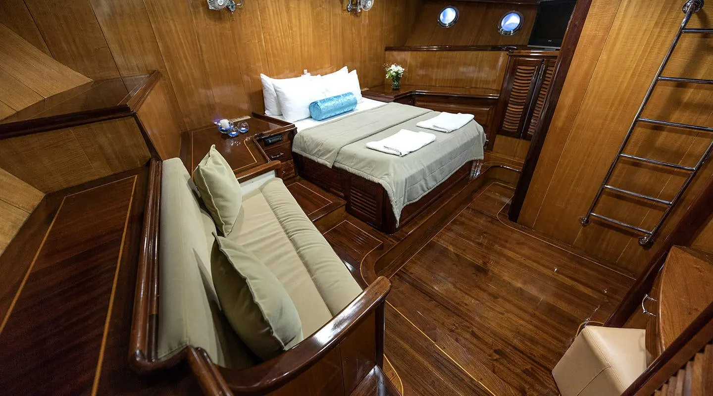 Kayhan 8 yacht interior with wooden floors, seating, and two beds in cabin