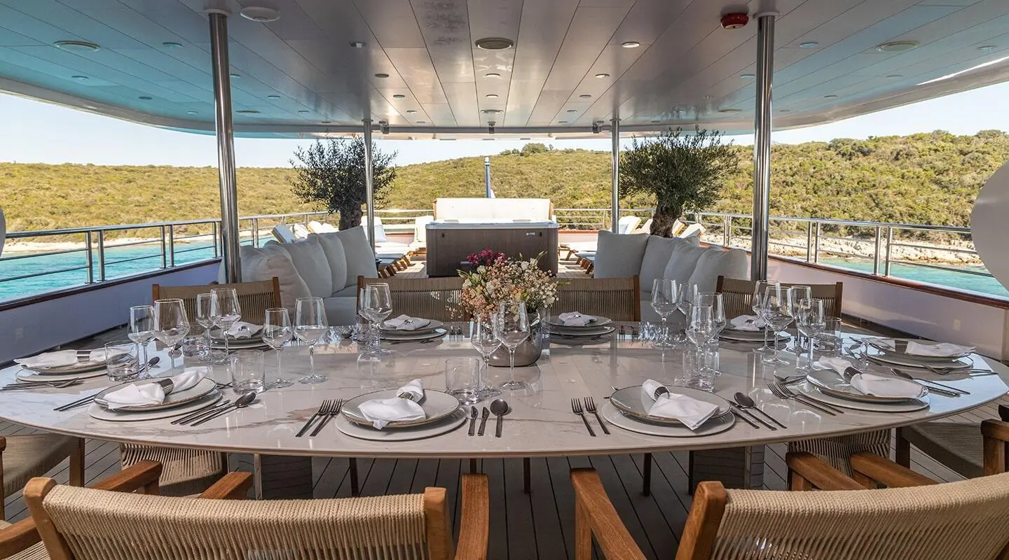 Olimp luxury yacht dining table setup on deck at sunset