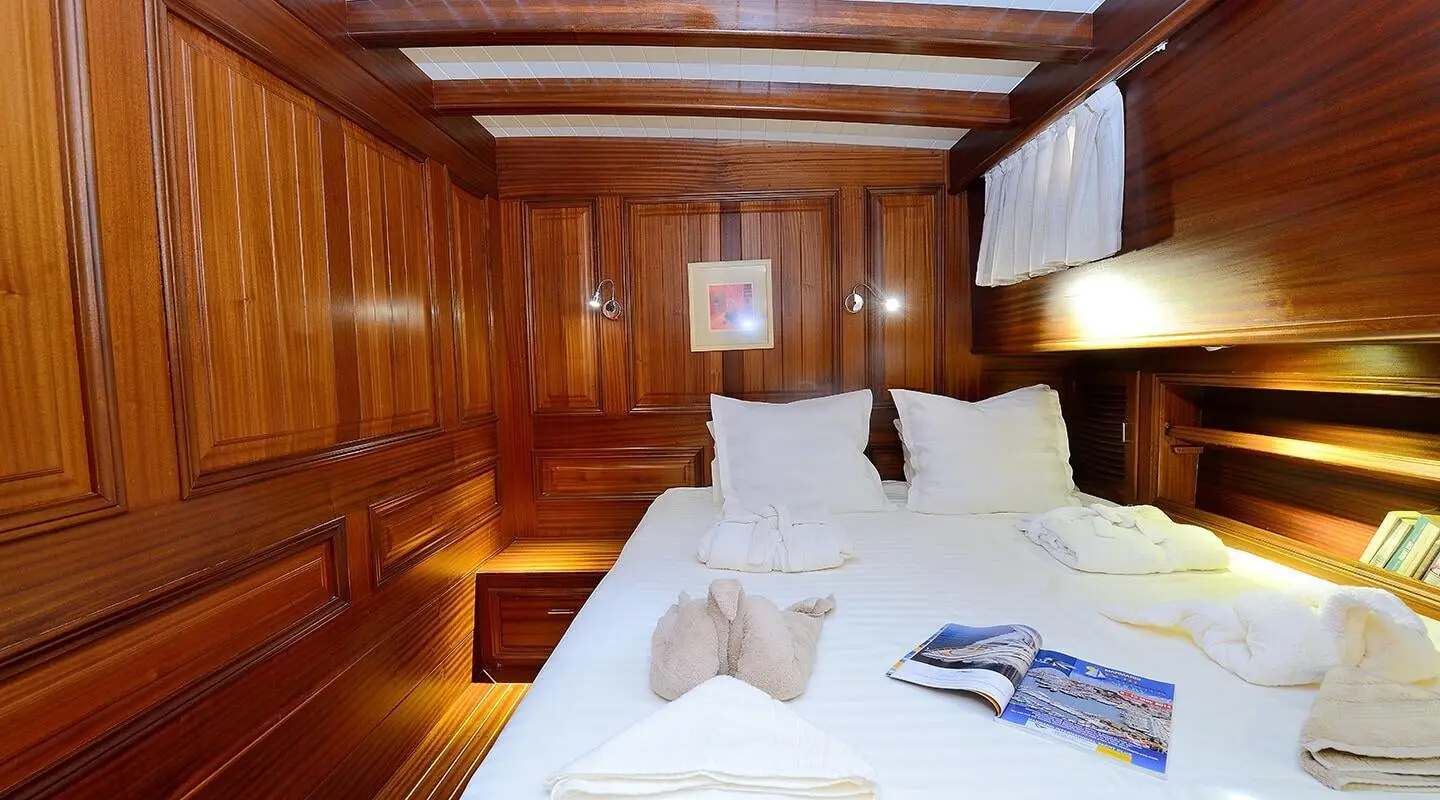 Wood-paneled gulet Samarkand cabin interior with bed and pillows