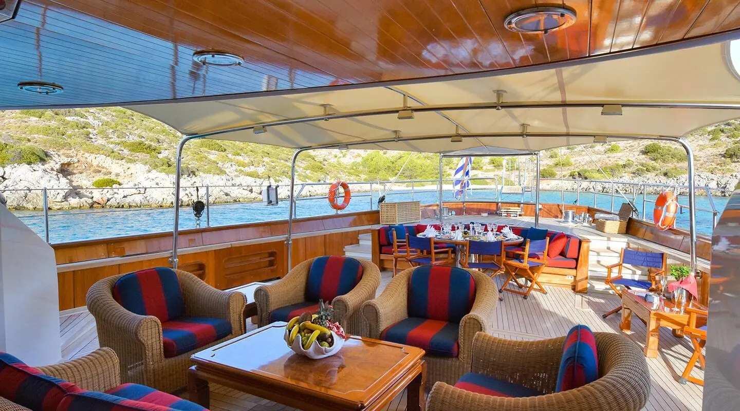 Cozy outdoor seating on Tamarita yacht with cushions, table, and sunshade