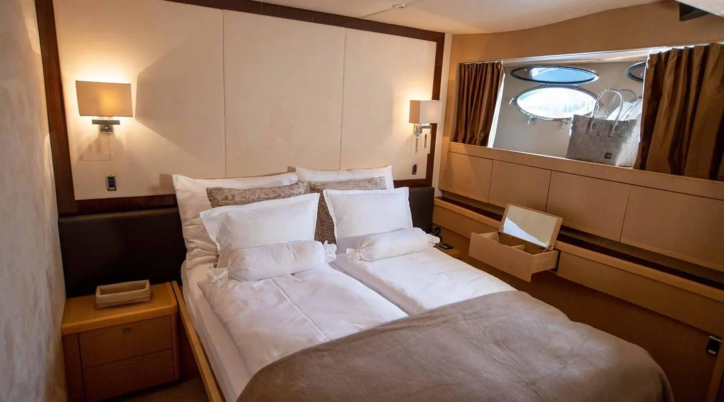 Luxurious double bed cabin with beige and cream tones in a yachting interior