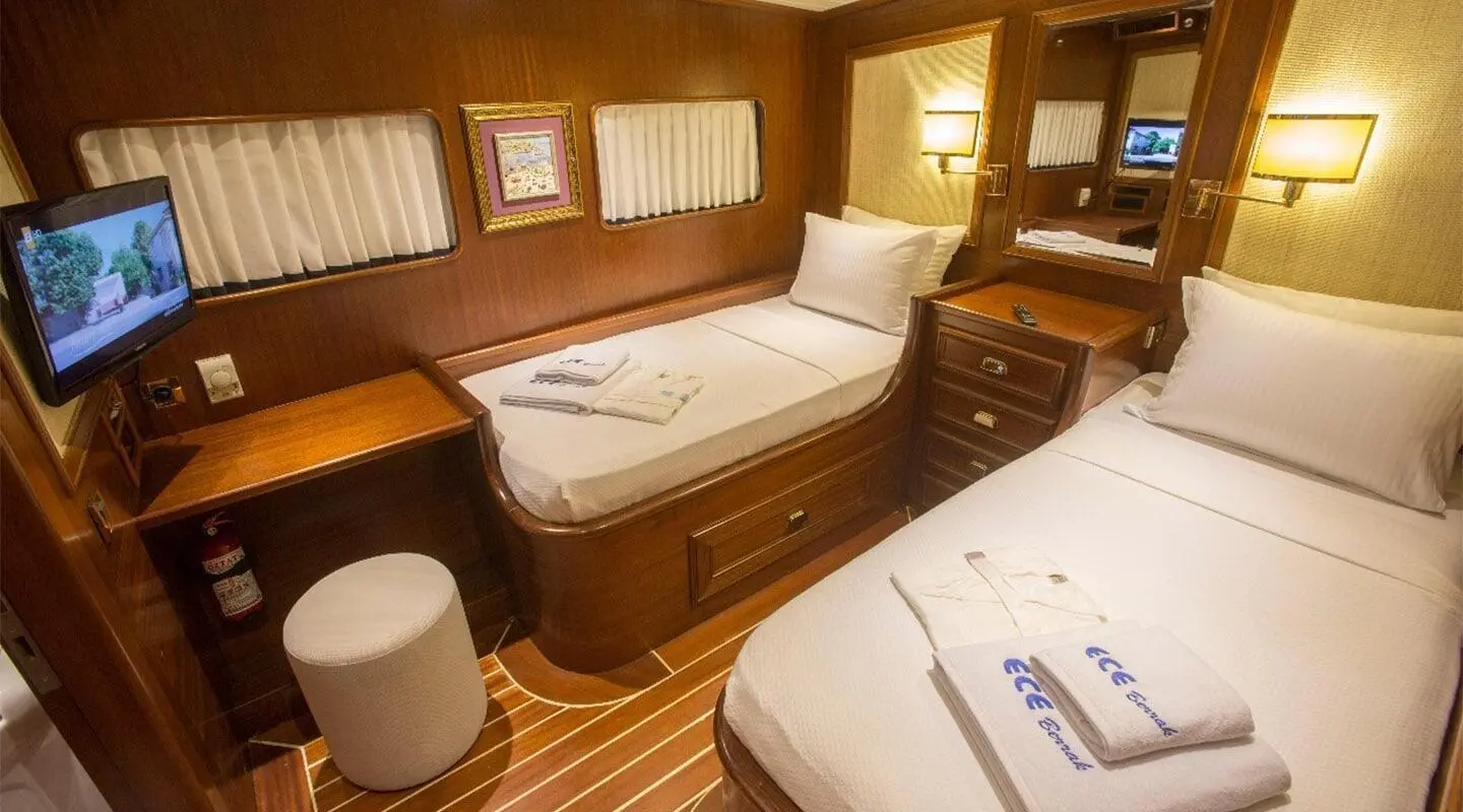 Twin cabin aboard Ece Berrak yacht with two single beds and wooden interior