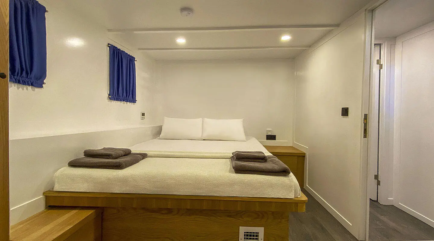 Yacht Maske 5 interior cabin with white bed, pillows, and soft lighting