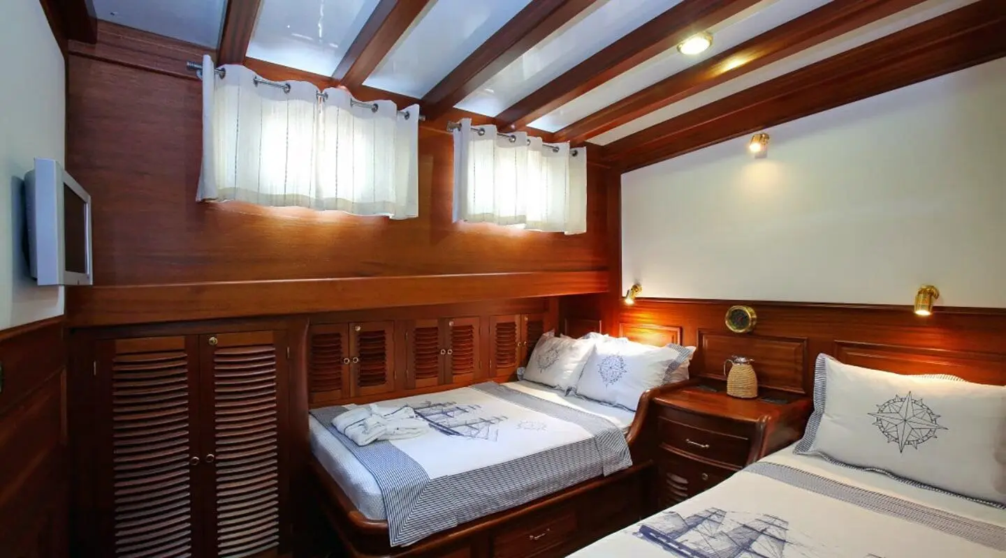 Cozy cabin interior of Kaya Guneri 4 with two single beds and wooden paneling
