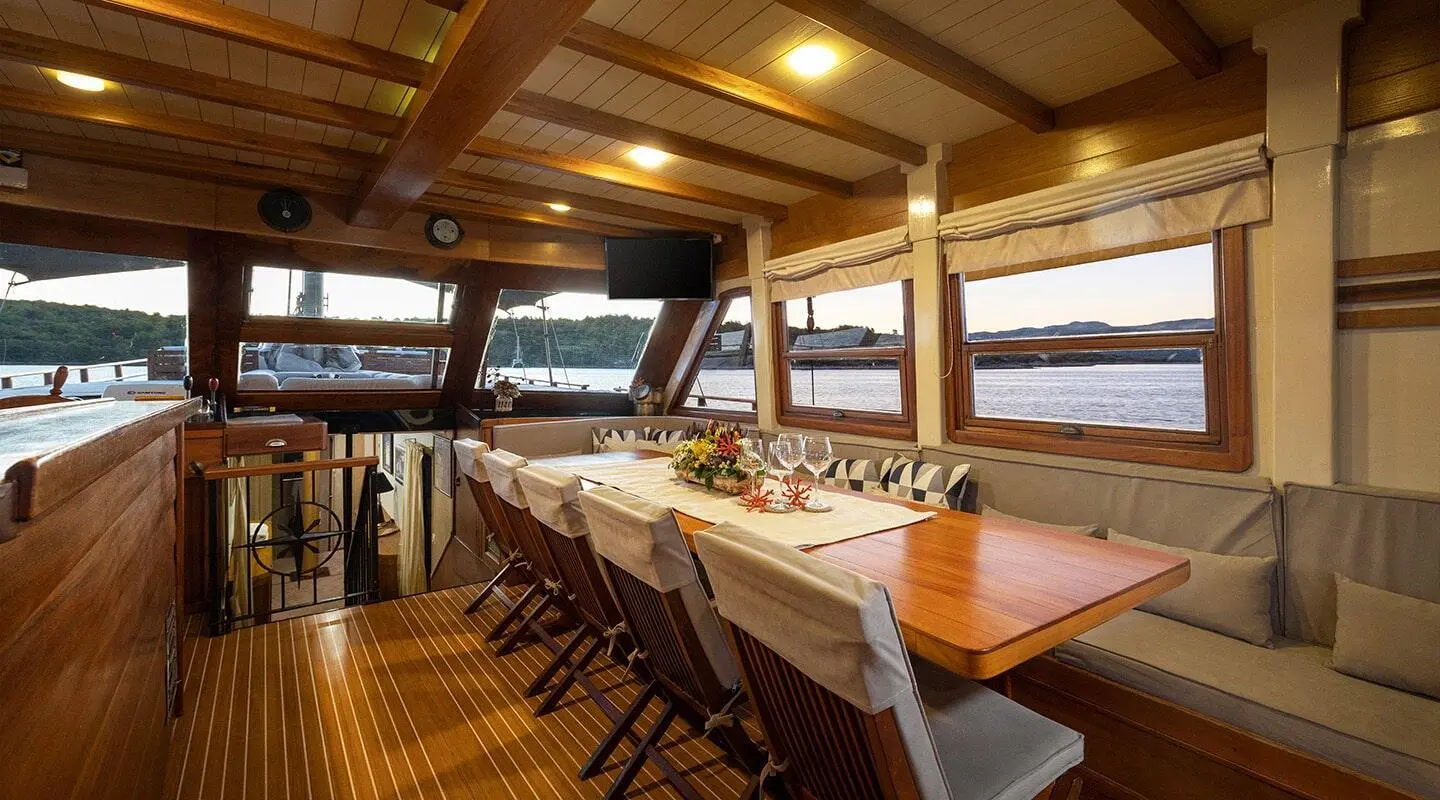 Interior of Aborda luxury gulet with wooden deck, table set for dining
