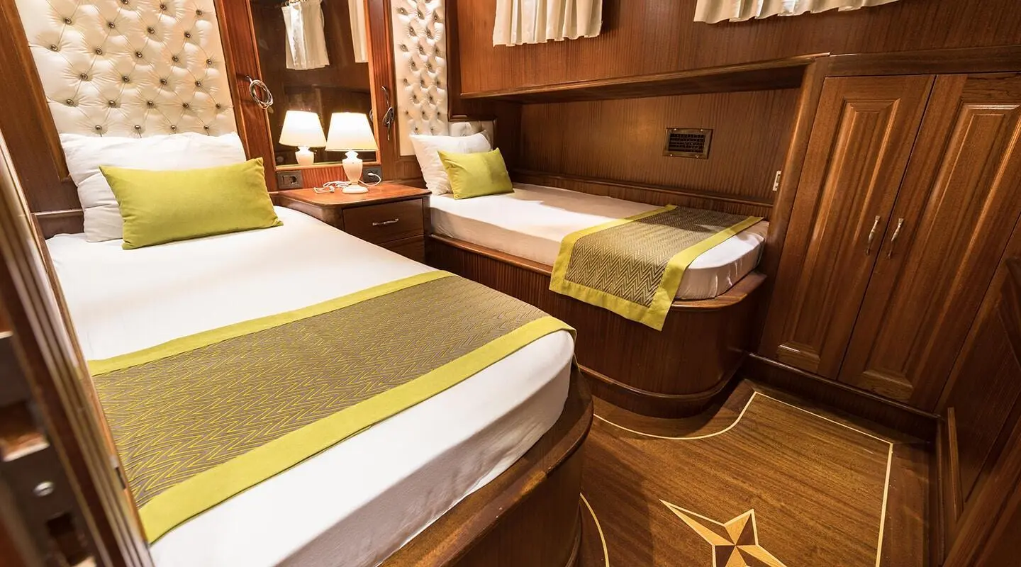 Vista Mare yacht interior with twin beds, warm wood paneling, and seating