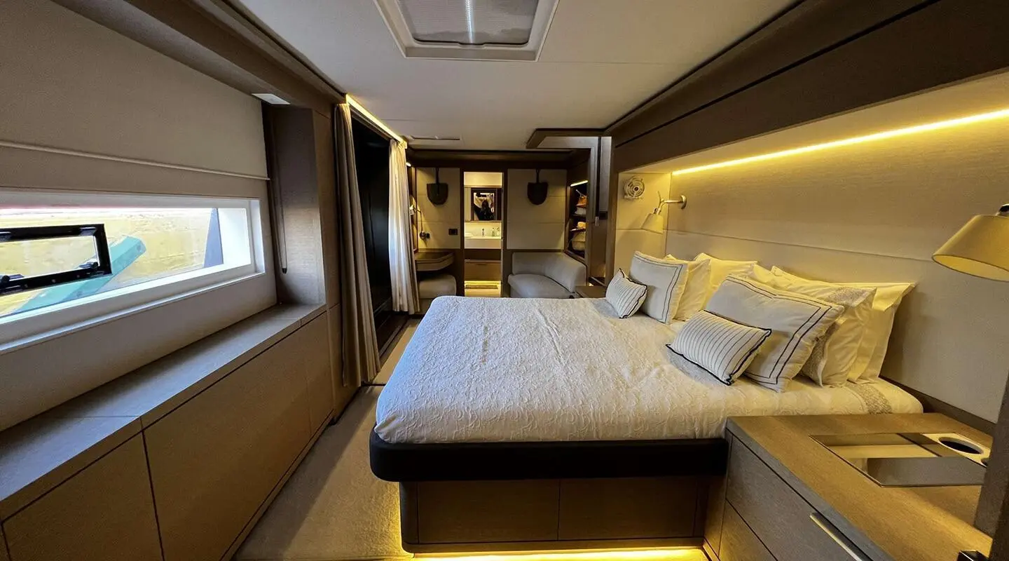 Luxurious bedroom aboard yacht with large bed and seating area