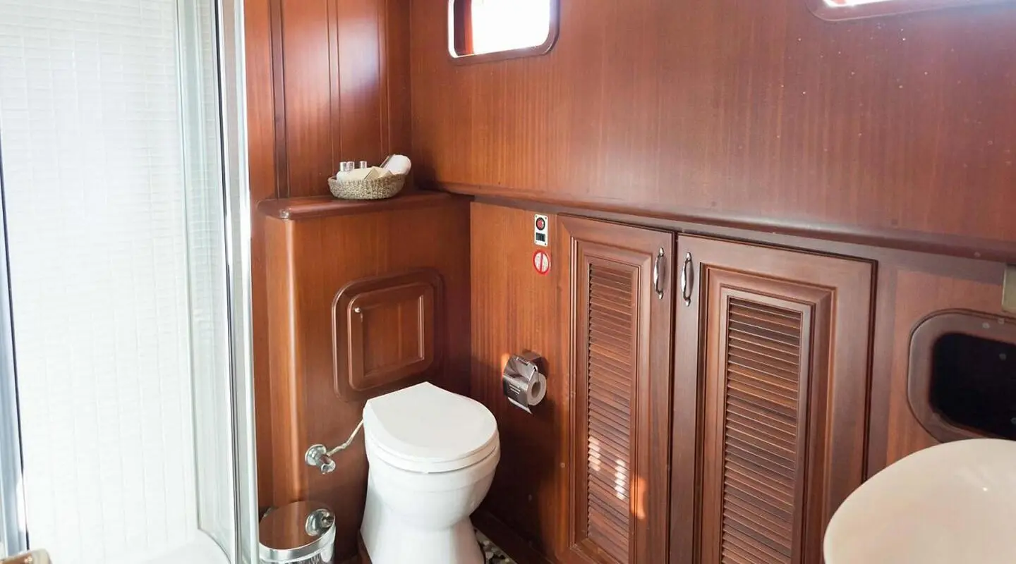 Primadonna yacht interior scene with wooden cabinetry and toilet area.