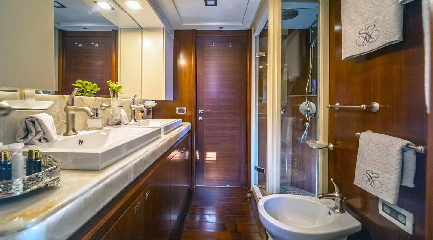 Interior view of a luxury motor yacht Seventh Sense with polished wood, bar seating, and doorway to deck