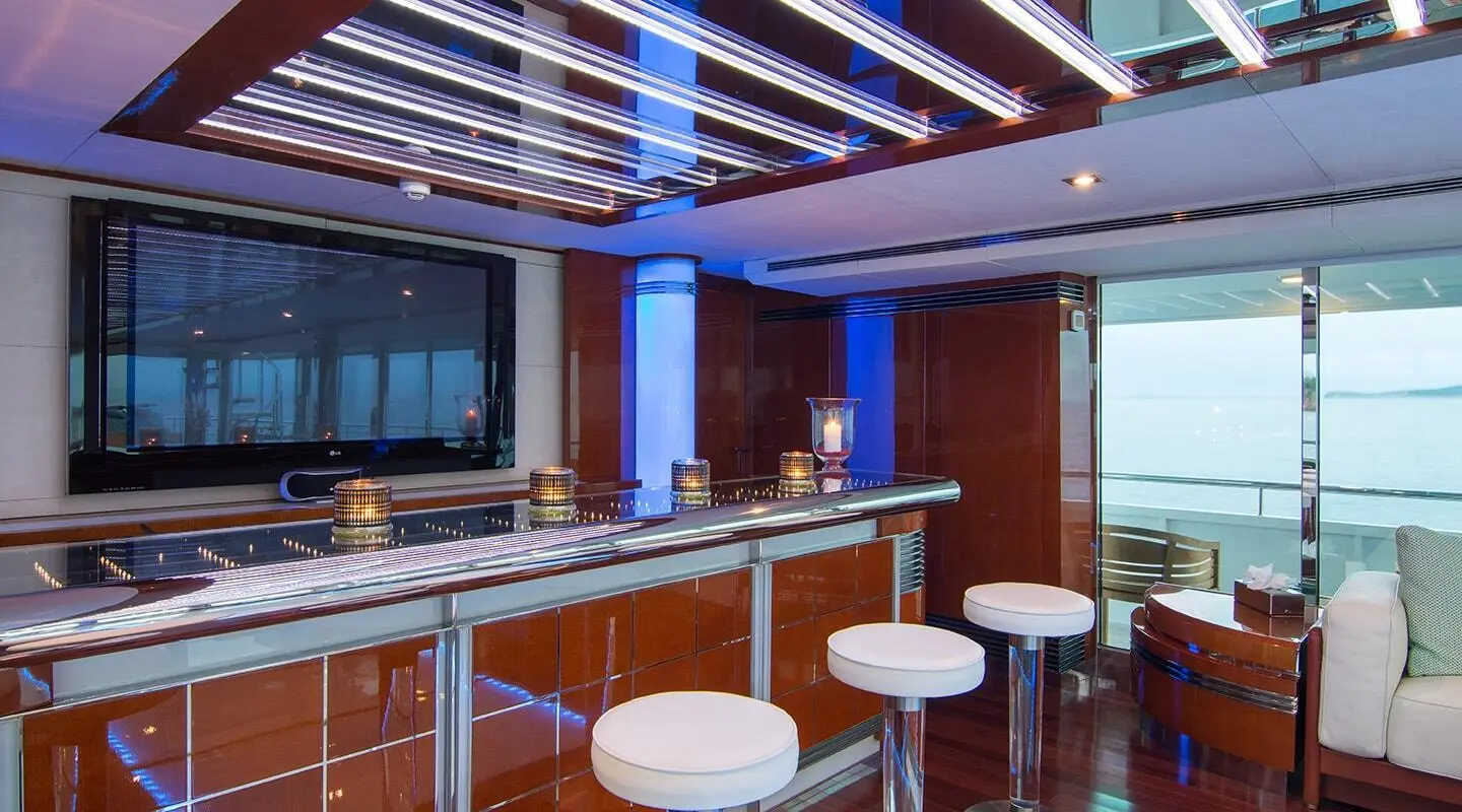 O'Natalina luxury yacht bar deck at sunset with stools and glass railings
