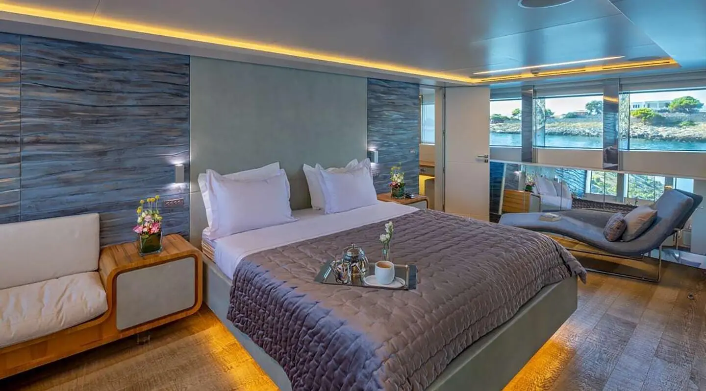 Sea Wolf luxury yacht bedroom with large bed, pillows, ambient lighting, and sea view
