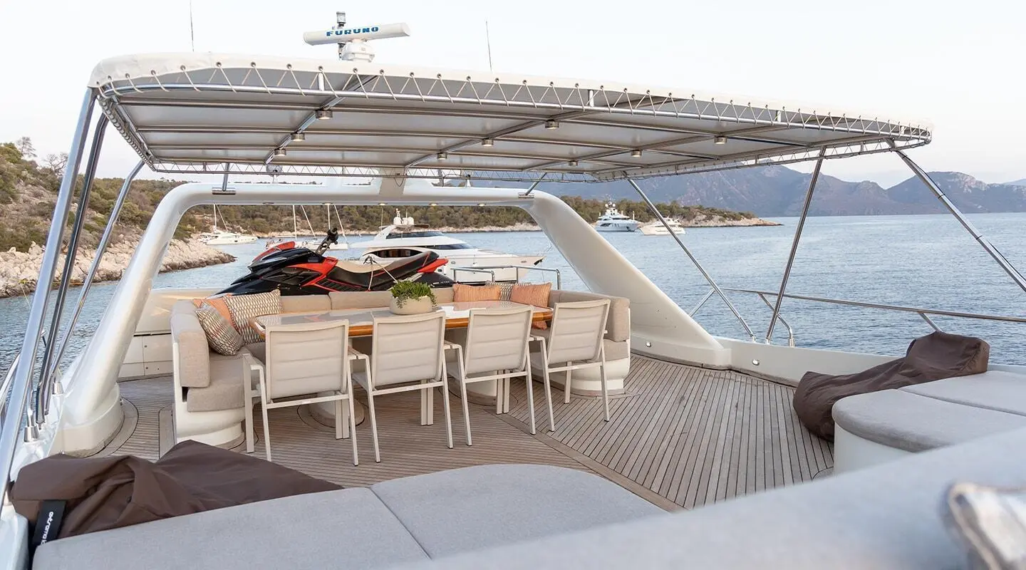 Aquila motor yacht flybridge with seating area and railing overlooking the sea