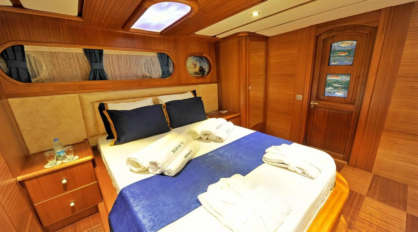 Gulet Berrak Su interior with a double bed cabin and wooden wardrobes