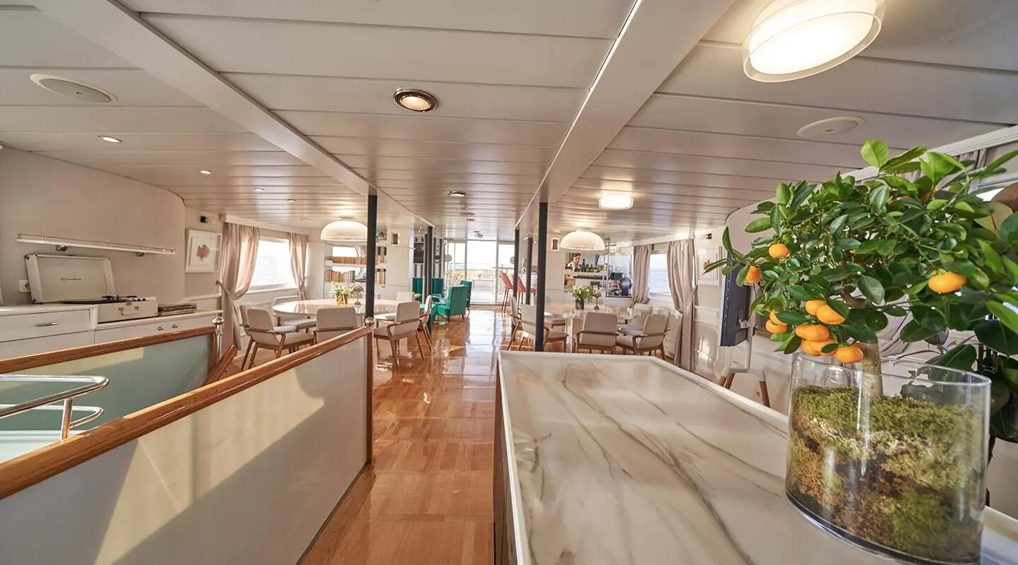 La Perla yacht interior salon with polished wood, seating, and soft lighting
