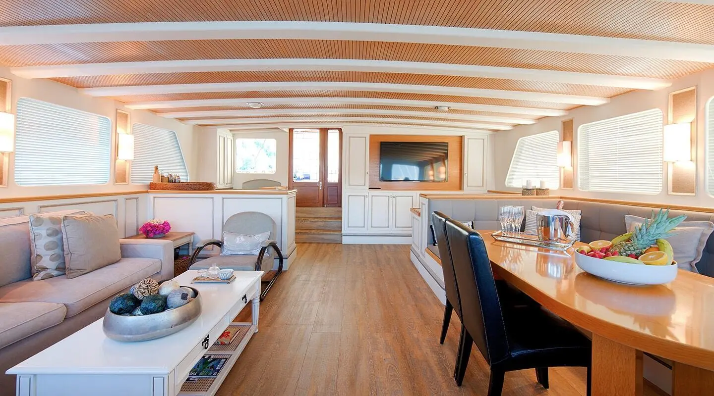 Cobra King yacht saloon interior with wooden floors, white seating, and a flat screen TV