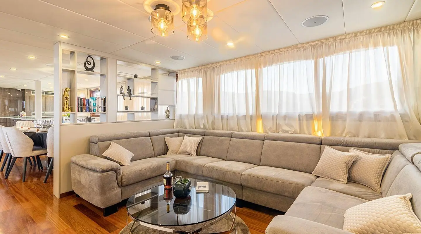 Luxurious interior of Melody yacht with beige seating and glass coffee table
