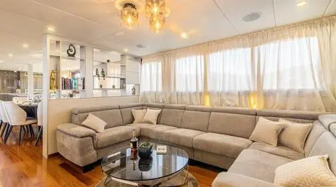 Luxurious interior of Melody yacht with beige seating and glass coffee table