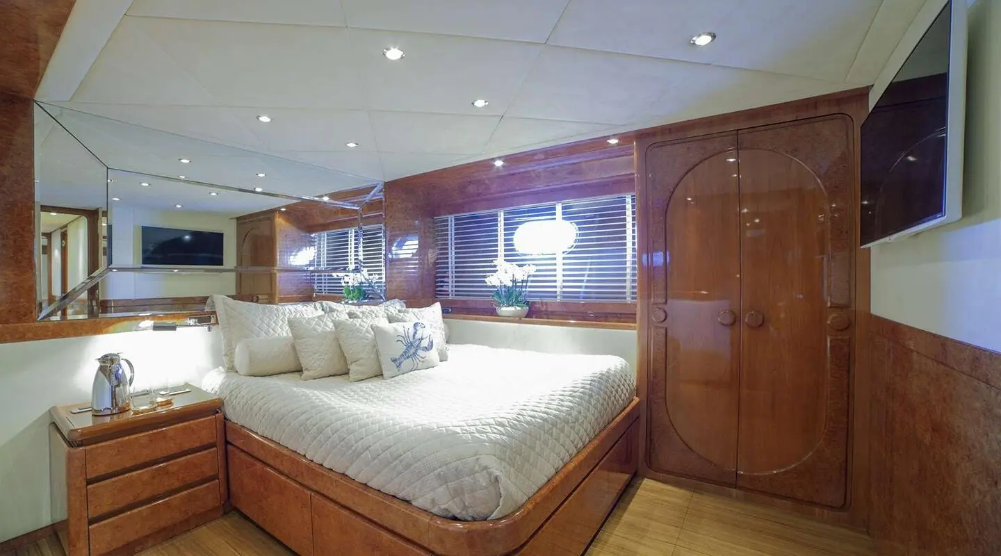 Lounge area on Zoi yacht with bed, wooden cabinets, and warm lighting