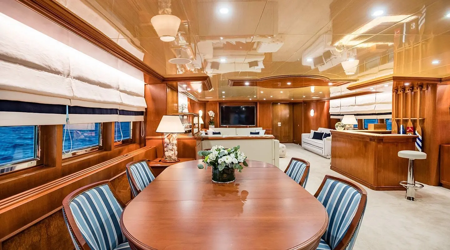 Interior dining area of Wind Of Fortune yacht with round table and wooden panels