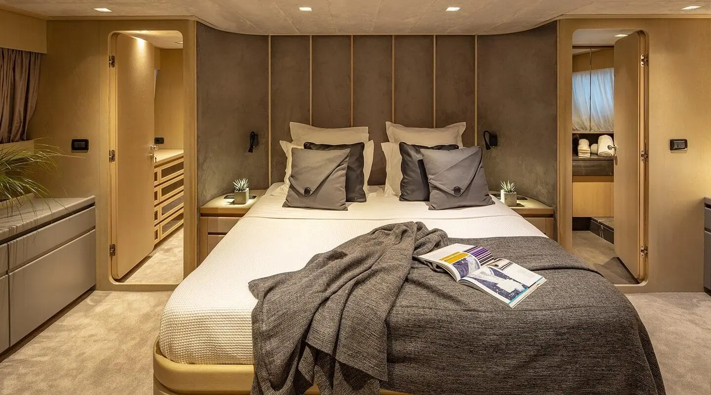 Cozy yacht cabin with two beds, pillows, and a blanket arrangement