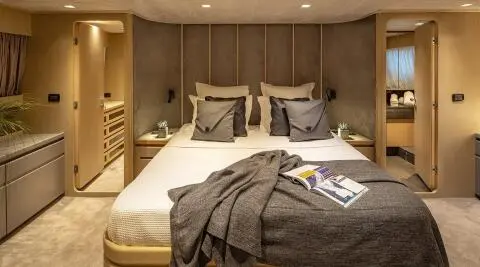 Cozy yacht cabin with two beds, pillows, and a blanket arrangement