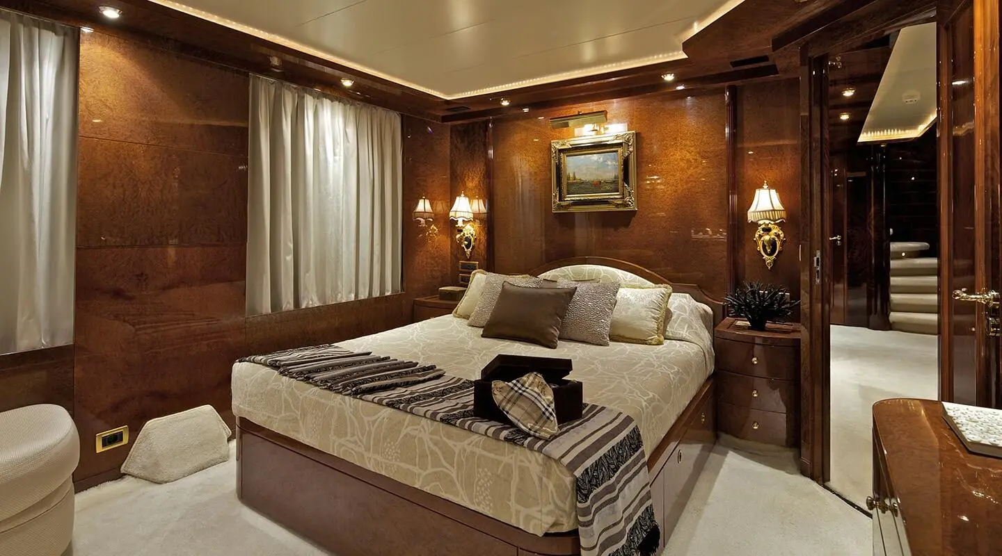 Luxurious master cabin aboard O'Rion yacht with polished wood panels and plush bedding