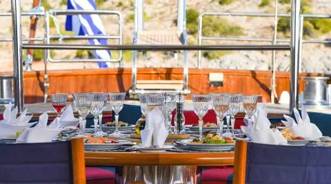 Tamarita yacht dining area at sunset with table settings and amber lighting