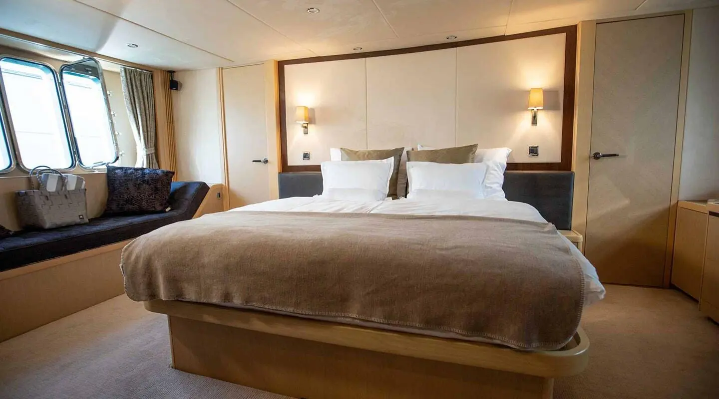 Luxurious yacht Insieme bedroom with large bed and soft lighting