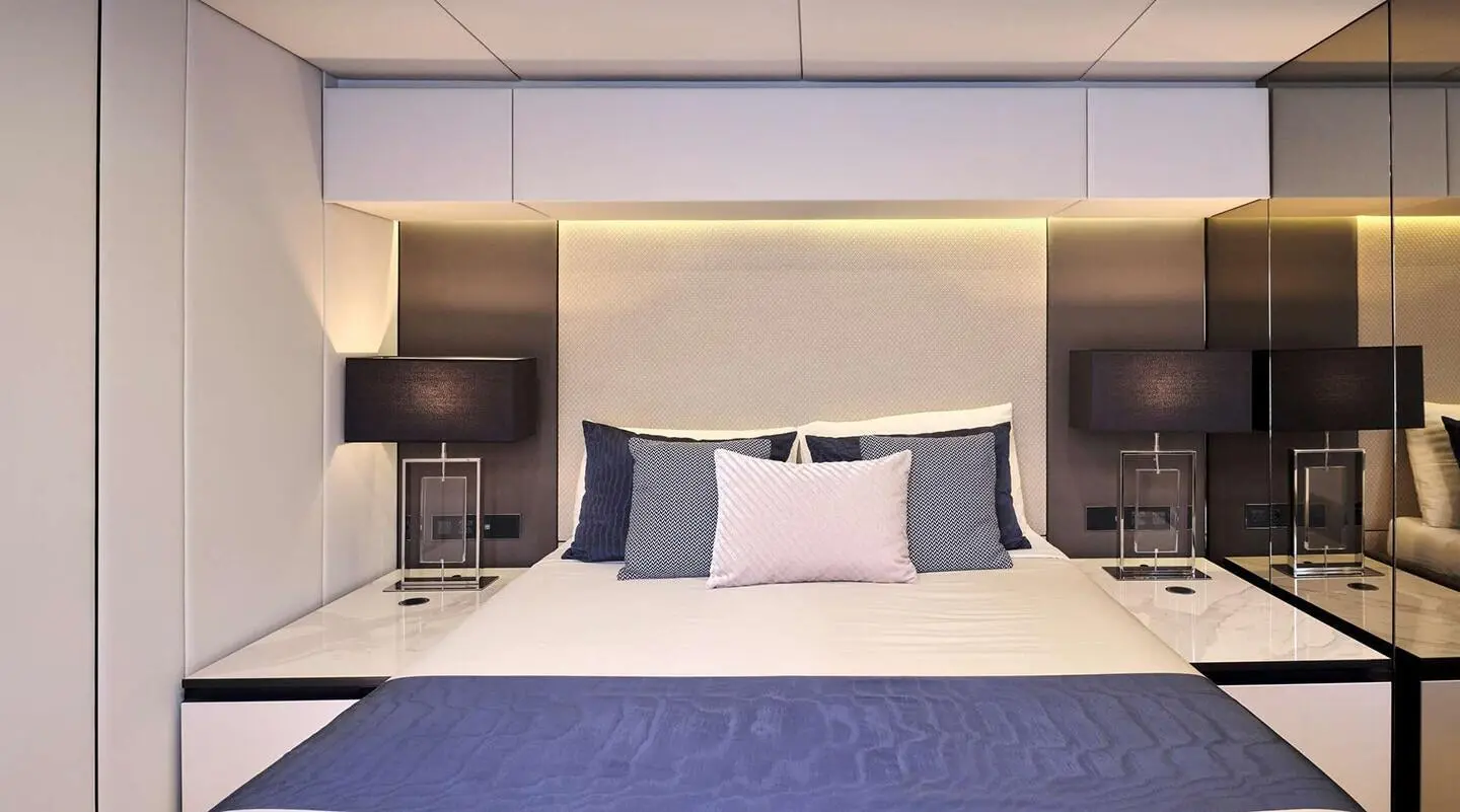 Luxurious bedroom on Genny yacht with bed, pillows, and ambient lighting