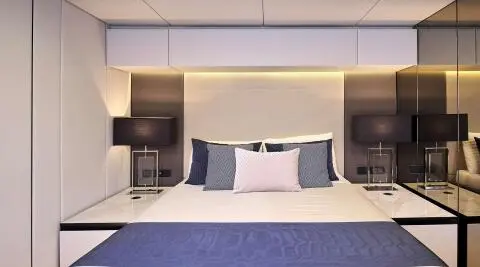 Luxurious bedroom on Genny yacht with bed, pillows, and ambient lighting