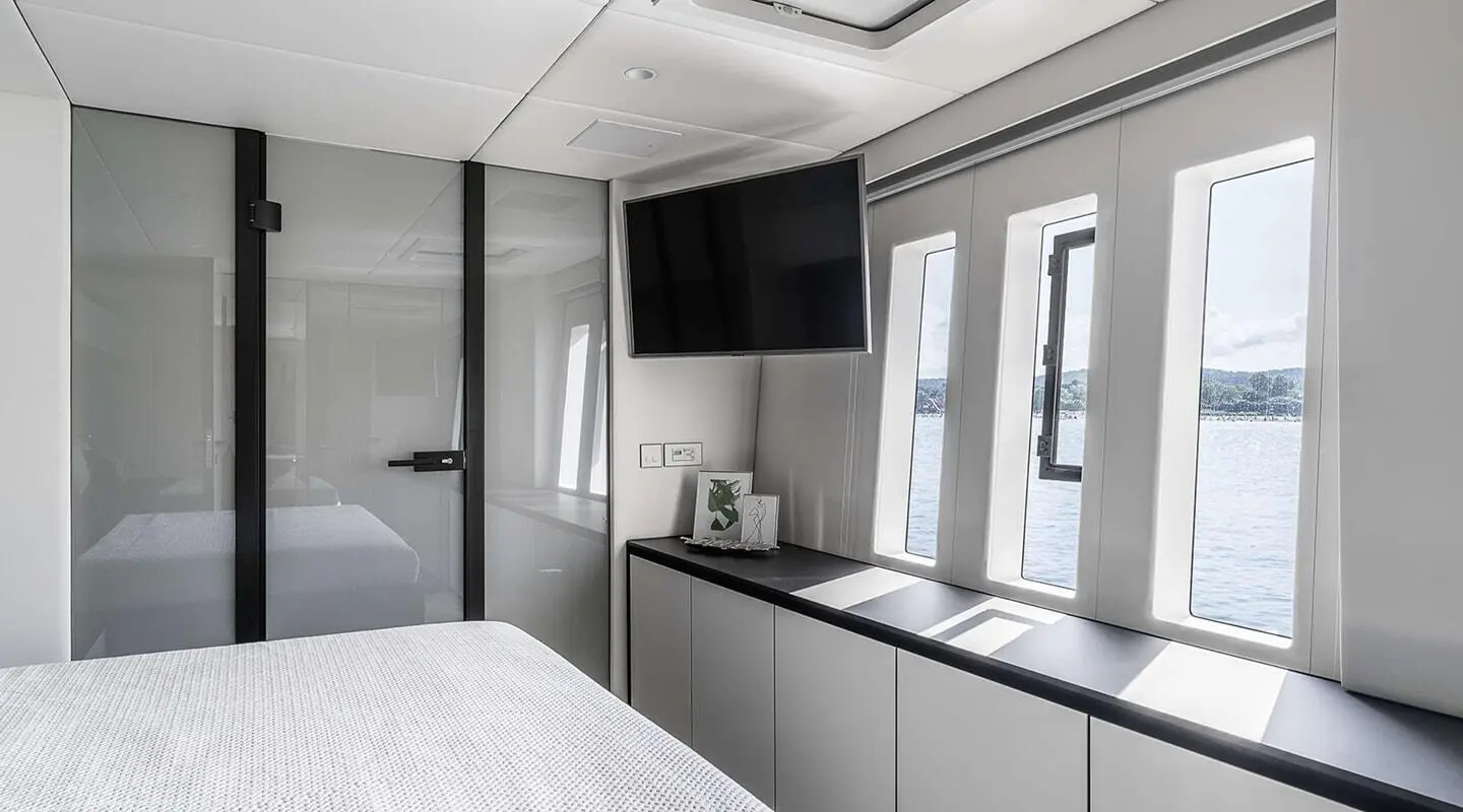 Interior cabin with bed, cabinets, window, and TV on a yacht