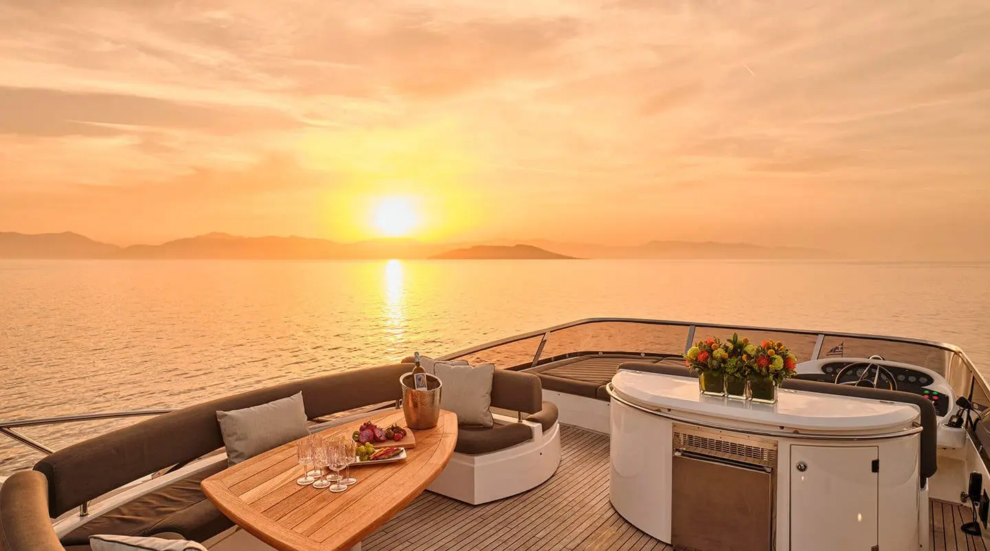 Sunset on M Five yacht deck with seating and ocean horizon view