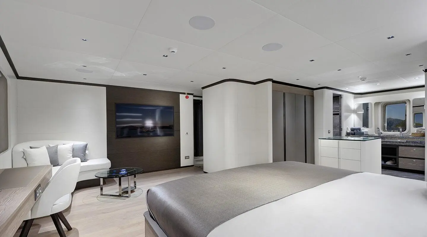 Luxurious yacht bedroom with large bed, modern seating, and ambient lighting