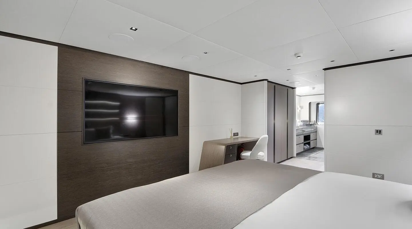 Modern bedroom with a wall-mounted TV and desk area
