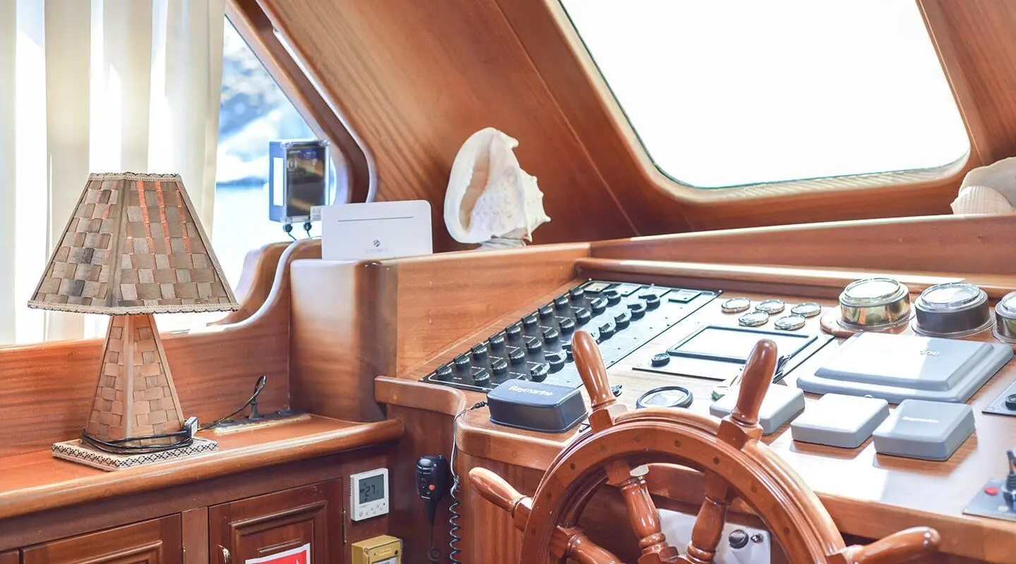 Lady Christa yacht wheel and helm controls inside polished wooden bridge cabin