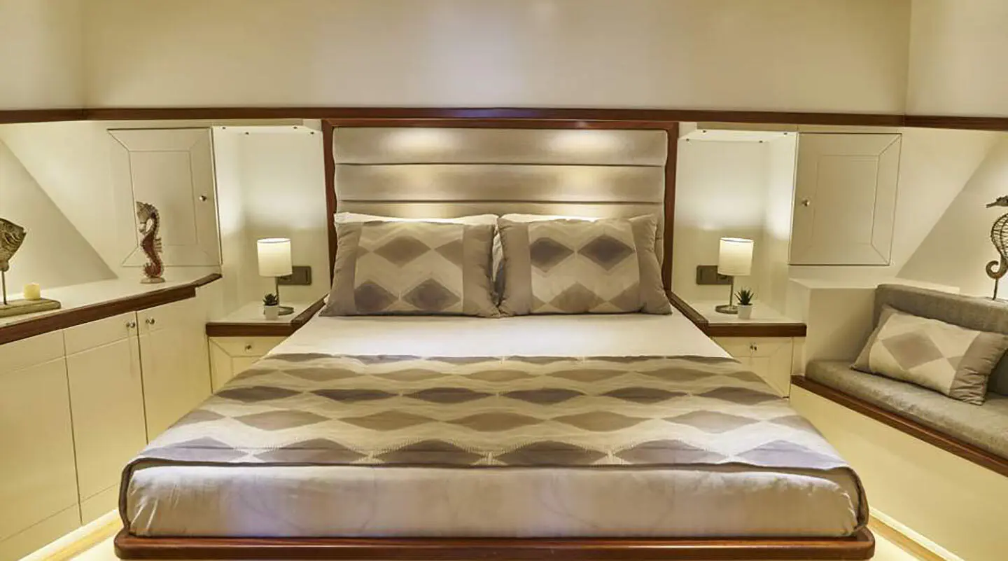 Grand Sailor yacht interior with elegant bed, cushions, and soft lighting