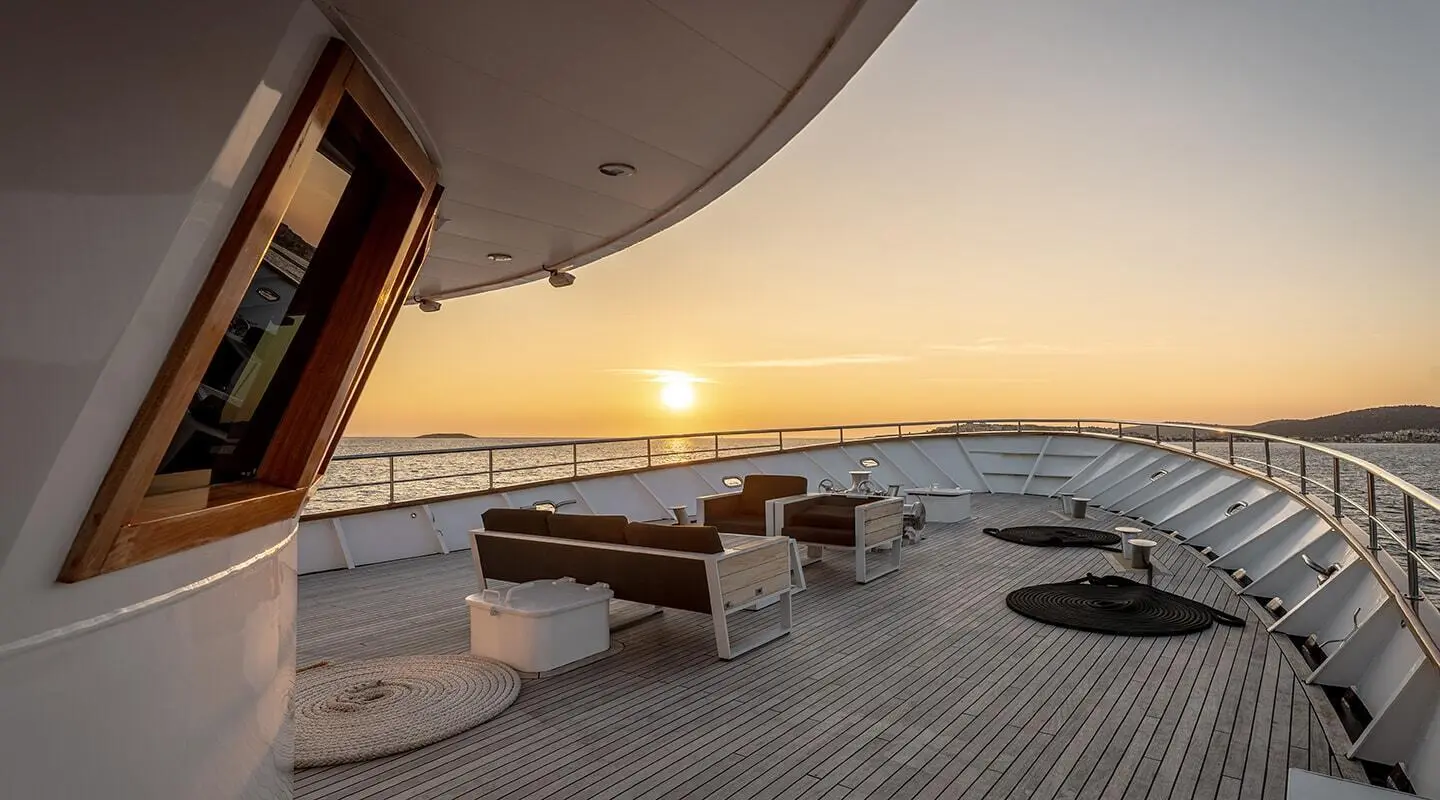 Karizma yacht deck at sunset with seating area and panoramic ocean view