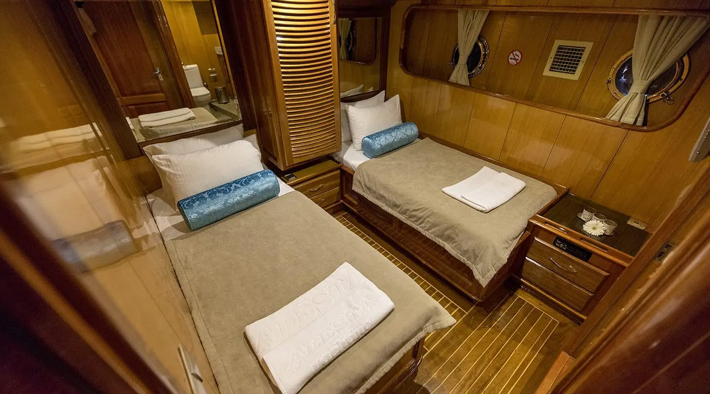 Kayhan 5 yacht interior with wooden cabins and neatly folded towels on berths