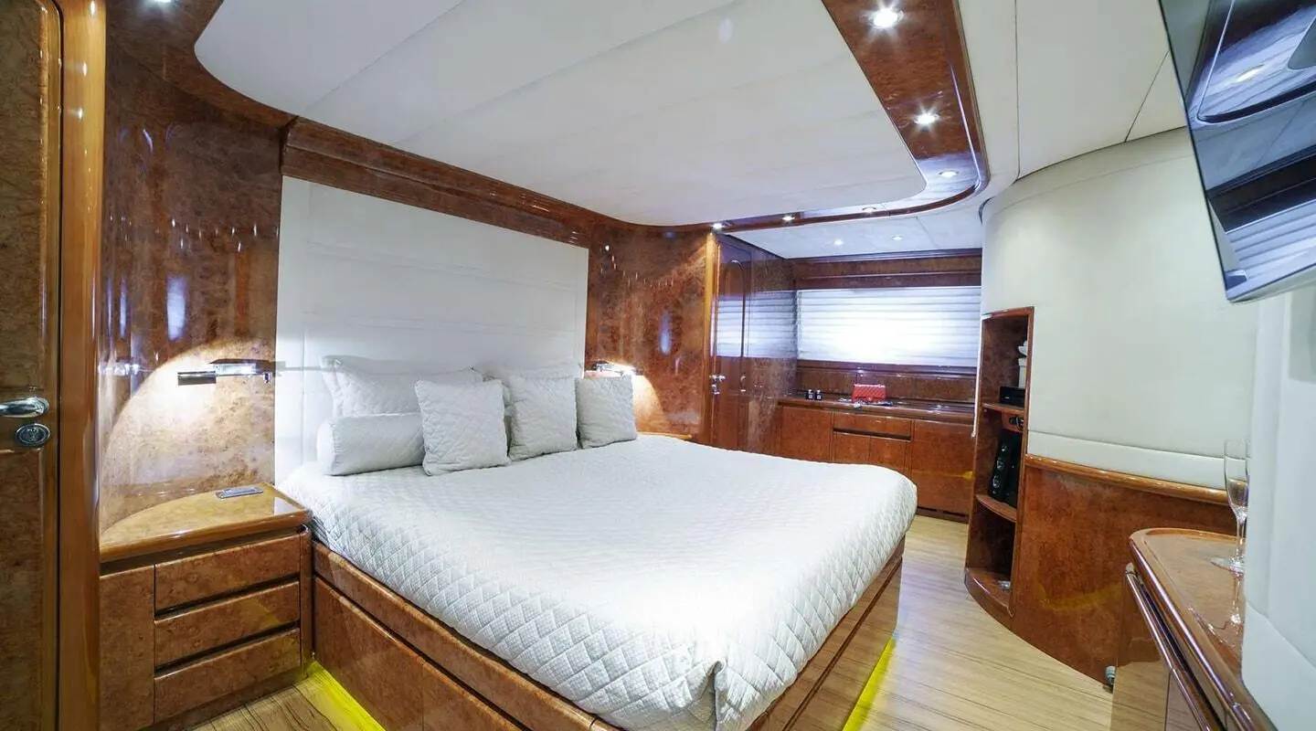 Cozy yacht bedroom with white bed, wood accents, and soft lighting