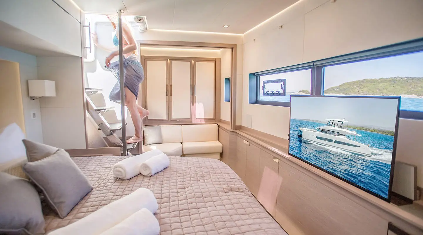 Interiors of D2 luxury yacht: lounging area with white sofas and flat screen TV