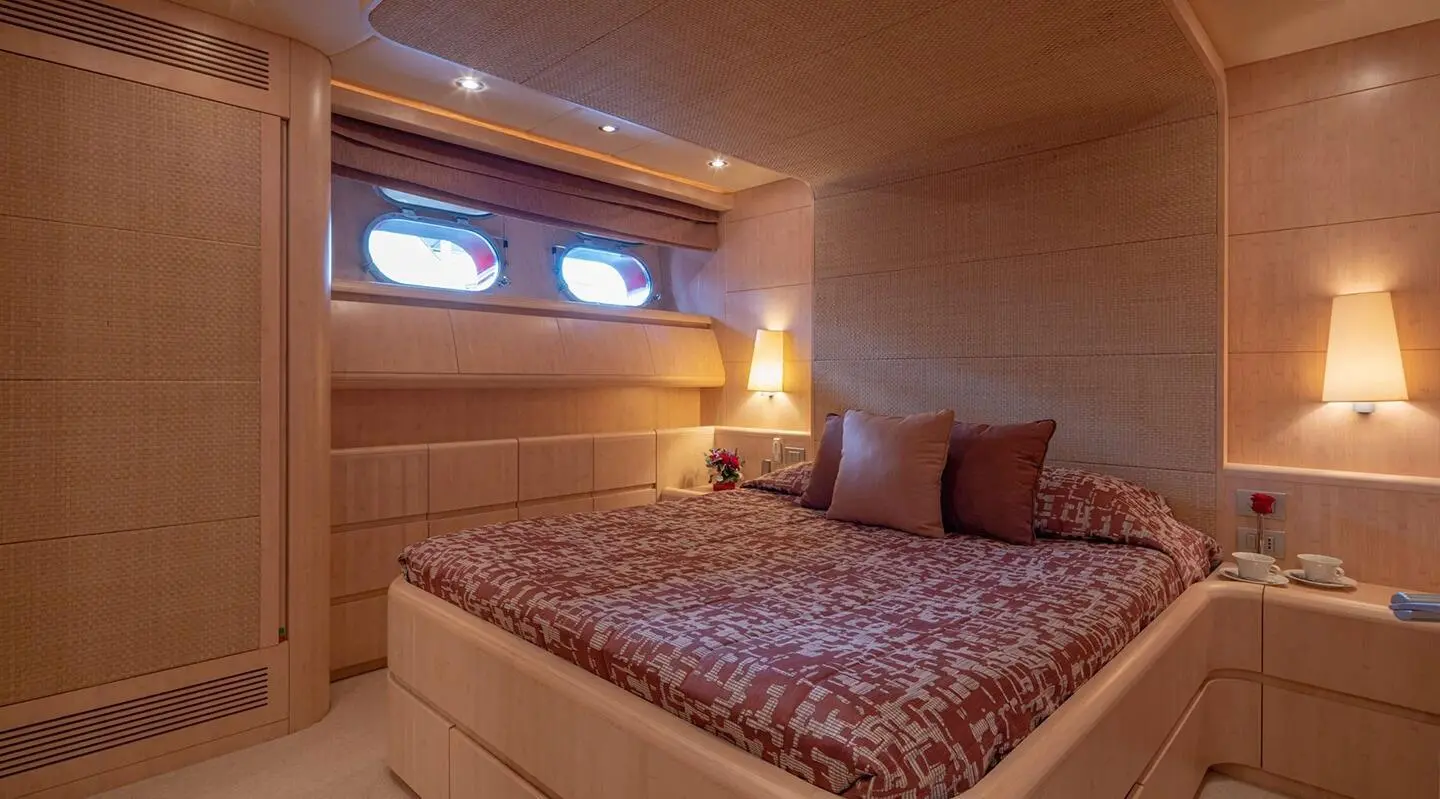 Glaros yacht bedroom interior with warm lighting and twin porthole windows