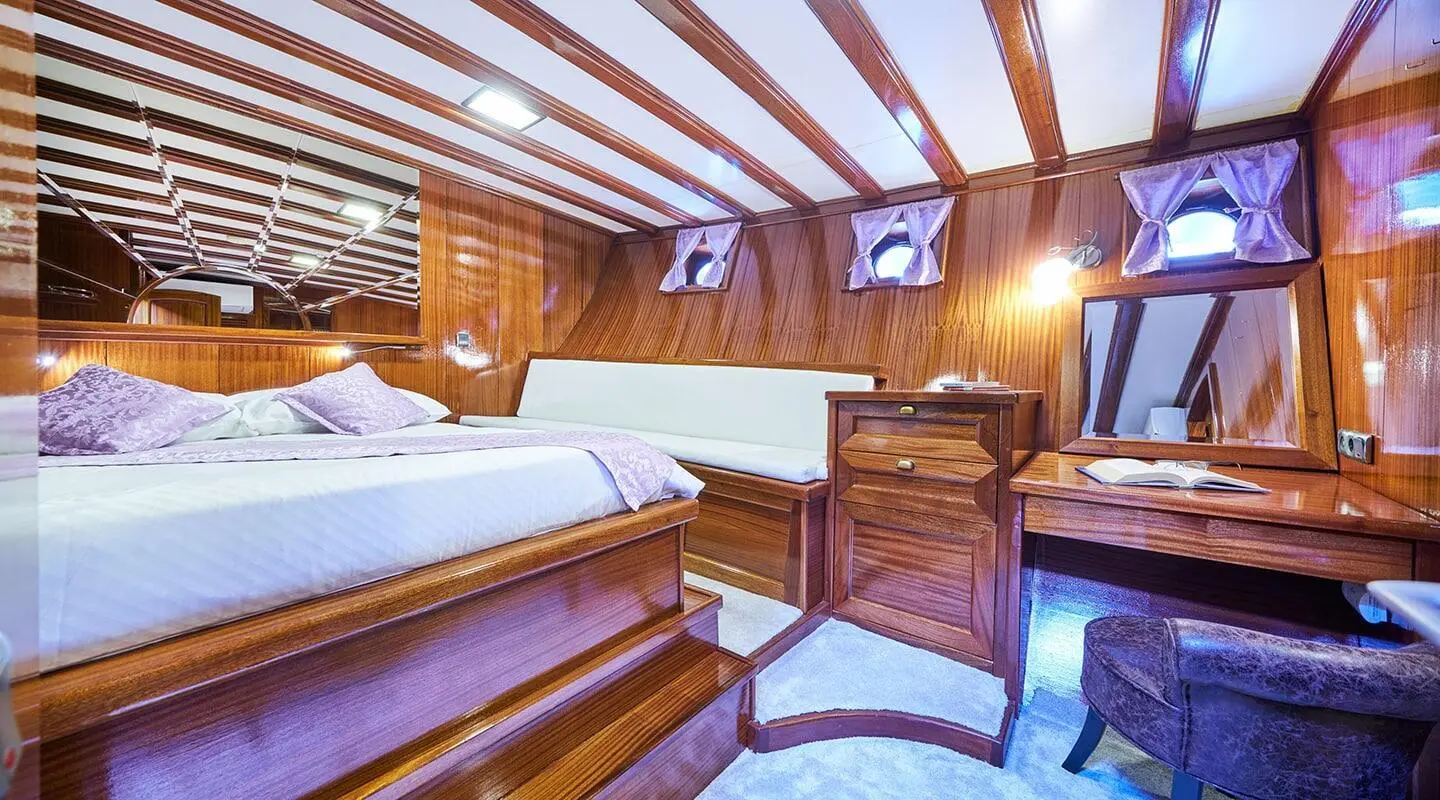 Interior of Stella Maris gulet; wooden flooring and two beds in a double cabin