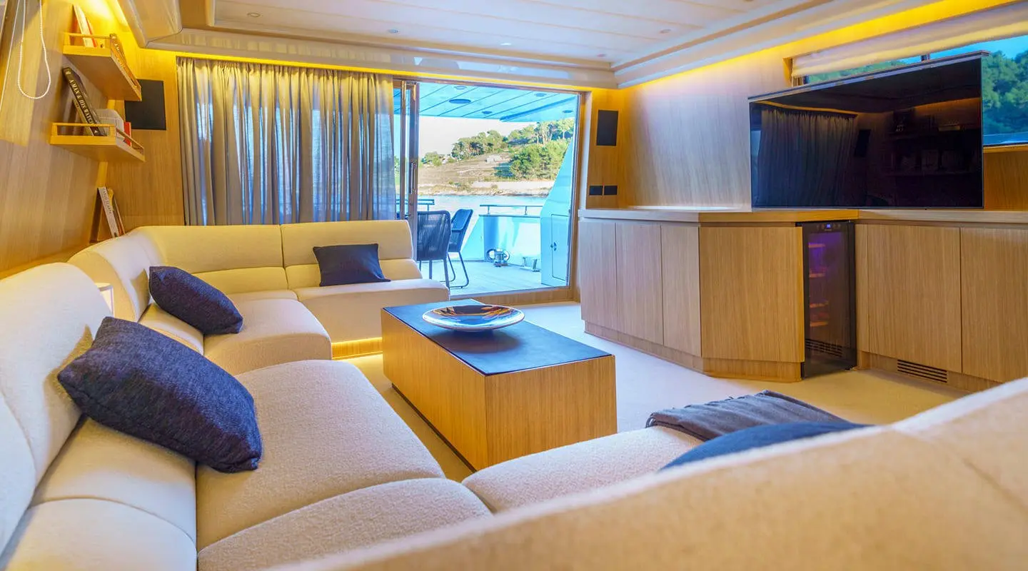 Phantom yacht salon at sunset with cream seating, wooden table, and large windows