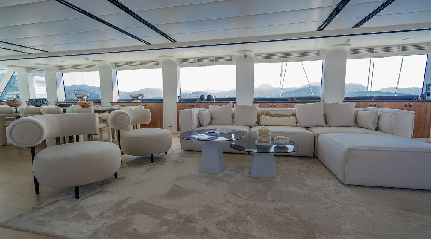 Yacht De Love interior: bright lounge with cream sofas and glass coffee table